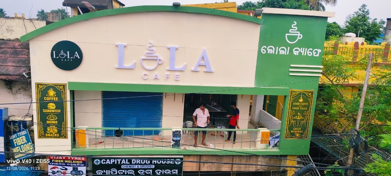 Lola Cafe shopfront in Bomikhal, cream wall with sage tower and Odia wordmark