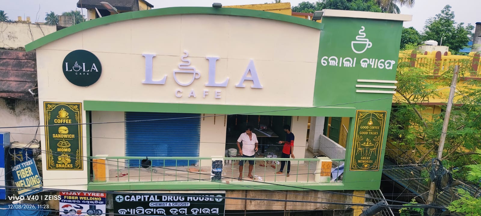 Lola Cafe first-floor facade above Capital Drug House and Vijay Tyres