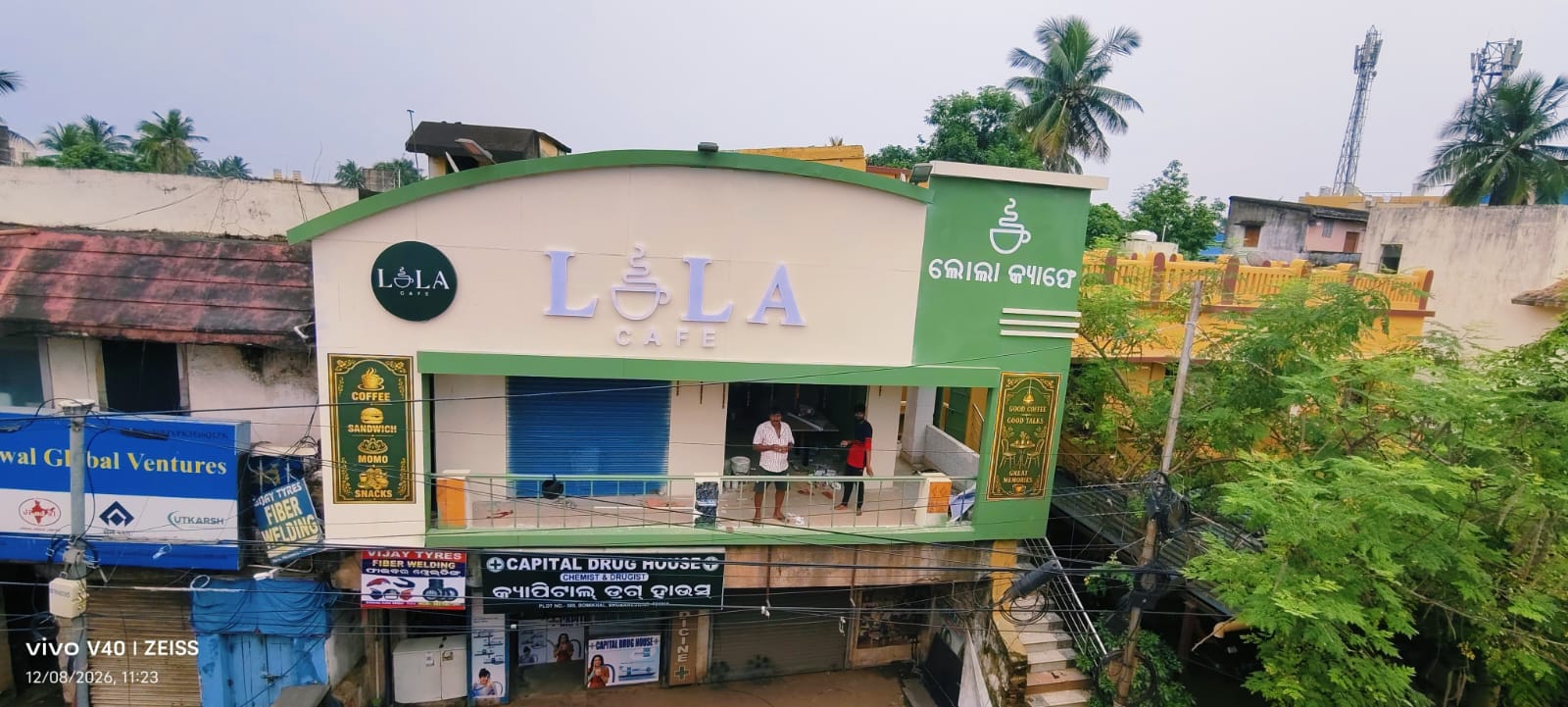 Wide view of Lola Cafe above Capital Drug House and Vijay Tyres